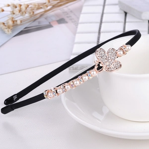 Detail of rose gold butterfly headband with pearls and rhinestones on ceramic