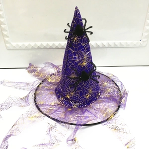 Detail of purple mesh witch hat featuring gold spider web print and fuzzy spider accents
