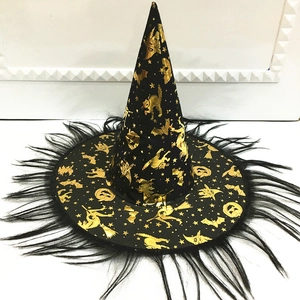 Primer plano del sombrero de bruja negro con patrones dorados y borde de plumas finas