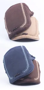 Detailed view of cotton canvas flat caps featuring style metal emblems and wavy stitching