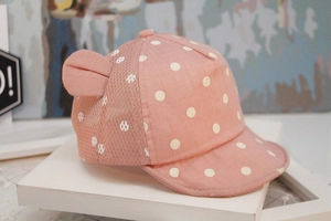 Close-up of pink baby sun hat with white polka dots, cute ears and breathable mesh detail