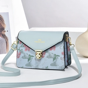 Light blue floral embroidered crossbody bag with golden flower clasp and adjustable strap