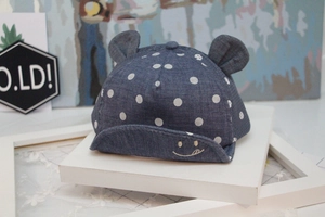 Detail of baby denim baseball cap with white polka dots, small ears and smile embroidery