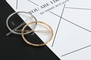 Detailed view of geometric round metal hair clips in gold and silver finish