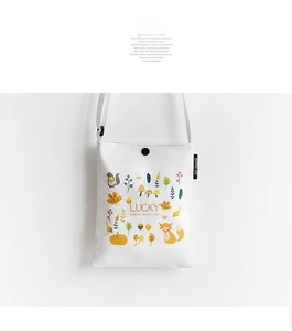 Detail view of the forest animal print and button closure on the white canvas bag