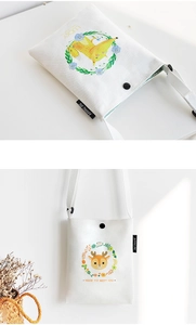Close-up of small white canvas crossbody bags with animal prints and lucky text
