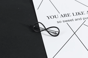 Detail of a black infinity symbol hair clip with a sleek matte finish and metal build
