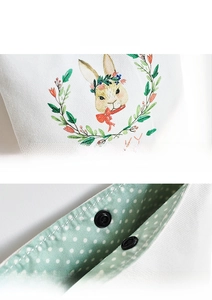 Detail of canvas bag showing lucky rabbit print and durable metal snap button closure