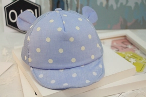 Macro view of blue polka dot baby baseball cap featuring soft brim and cute 3D ears