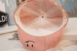 Detail of pink baby baseball cap showing smile embroidery and breathable mesh lining