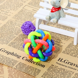 Colorful woven pet bell ball puzzle toy for dogs and cats on vintage background