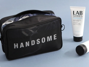 Detail of breathable black mesh bag with HANDSOME text for travel toiletries