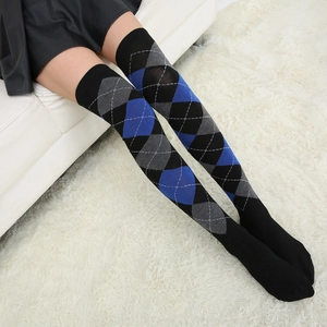 Detail of diamond pattern over-the-knee socks worn by a model on a white carpet