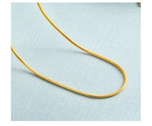 Close-up of golden snake chain necklace with smooth metallic texture and high polished finish