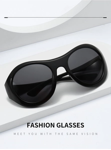 Detail of black butterfly oversized Y2K sunglasses on a white geometric display stand