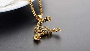 Close-up of a gold stainless steel scorpion pendant necklace with detailed metal craftsmanship