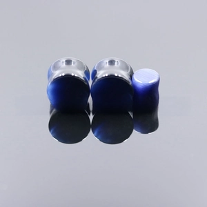 Macro view of three deep blue cat eye stone ear plugs with polished finish and reflection