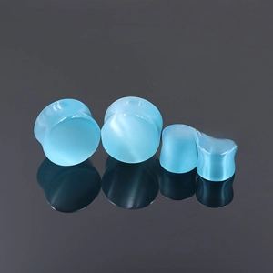 Macro detail of sky blue cat eye stone ear plugs showing translucent gloss and smooth finish