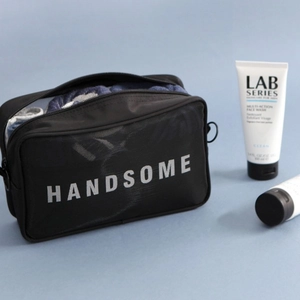 Black mesh travel toiletry bag for men with HANDSOME text and top zipper closure