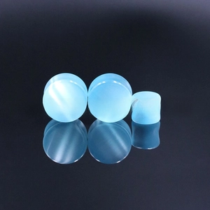 Macro view of blue cat's eye stone ear plugs with reflective vertical light bands