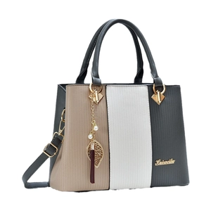 Sac bandoulière chic en patchwork avec texture verticale et breloques décoratives