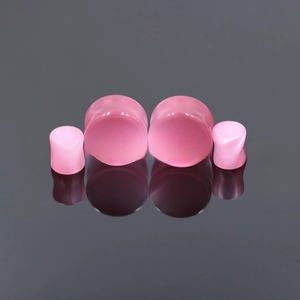 Detailed close-up of pink cat eye stone ear plugs showing the smooth polished surface