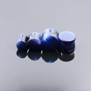Detailed macro view of four blue cat eye stone ear plugs with distinct optical textures