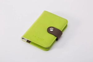Dettaglio del portamonete in pelle verde con incisione SUNNY e cinturino marrone