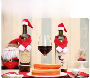 Miniature Christmas Santa hat and scarf wine bottle decoration on festive dinner table