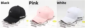 Detail view of cotton baseball caps with metal rings and embroidery in black, pink, and white
