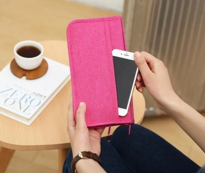 Detail of rose red travel passport wallet showing the front pocket for holding a smartphone