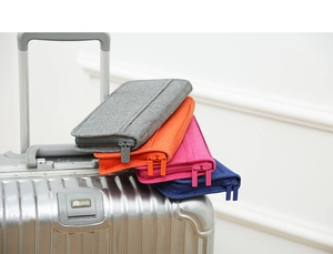 Travel passport holders in four colors stacked on top of a silver metal suitcase