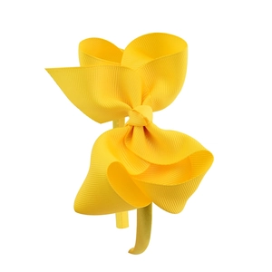 Detail of 4-inch bright yellow grosgrain ribbon bow on a flexible girls headband