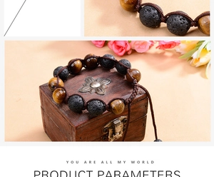 Detail of 12mm tiger eye and volcanic stone braided adjustable bracelet on a wooden box