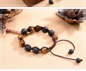 Detail of 12mm tiger eye and lava stone beads on a brown braided adjustable bracelet