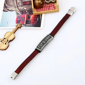 Vintage brown leather bracelet with metal plate engraved forgiven on white background