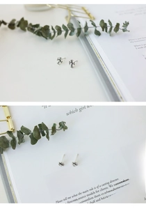 Macro shot of vintage S925 sterling silver cross stud earrings on an open book