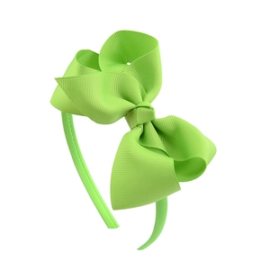 Detailed view of a bright green grosgrain ribbon bow on a flexible children headband