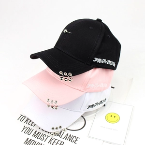 Detailed view of baseball caps with metallic rings on brim and side letter embroidery