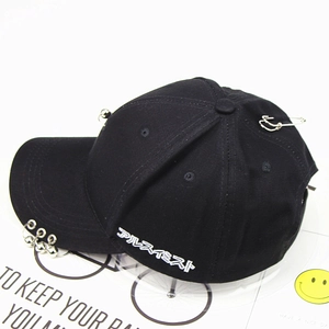 Detail of black cotton baseball cap with metal rings and silver pin street style decoration