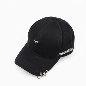 Detail of black baseball cap featuring silver metal rings and white Japanese embroidery