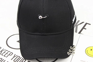 Detailed embroidery and silver ring charms on a punk style black cotton baseball cap