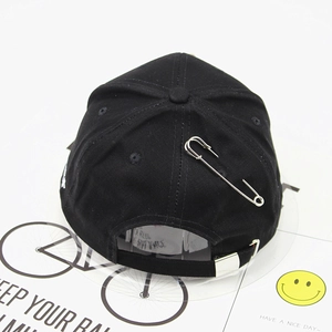 Black cotton baseball cap featuring silver safety pin detail and white embroidery decor