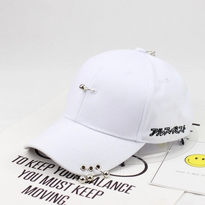 Detail of white cotton baseball cap featuring silver metal rings and black embroidery