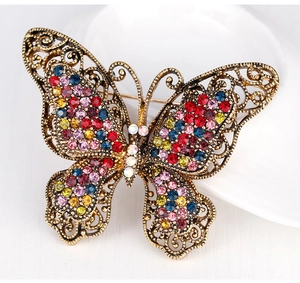 Detailed close-up of vintage butterfly brooch with colorful crystals and hollow metal design