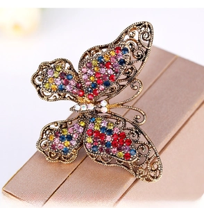 Detailed view of vintage butterfly brooch with colorful crystals on beige gift box