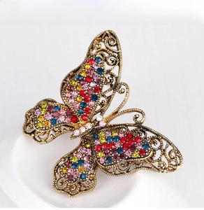 Macro shot of vintage butterfly brooch with colorful crystals and gold filigree metal