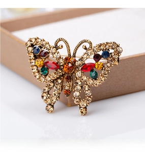 Macro detail of vintage butterfly brooch with colorful rhinestones on light gift box