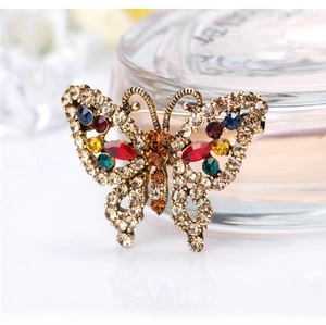 Macro shot of colorful rhinestones on a golden butterfly brooch for women