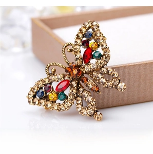 Close-up of vintage golden butterfly brooch with colorful rhinestones on jewelry display box